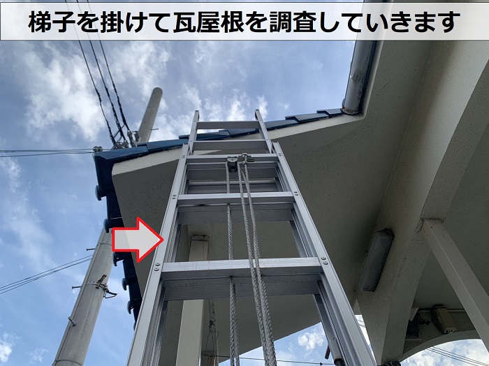 アパートの瓦屋根に梯子を掛けている様子