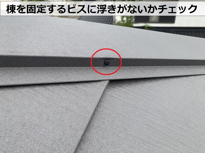 屋根工事後の定期点検で棟を固定するビスに浮きがないか確認している様子