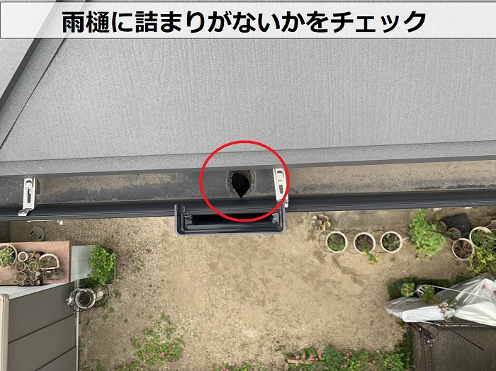 三木市での屋根工事後の定期点検で雨樋に詰まりがないかチェックしている様子