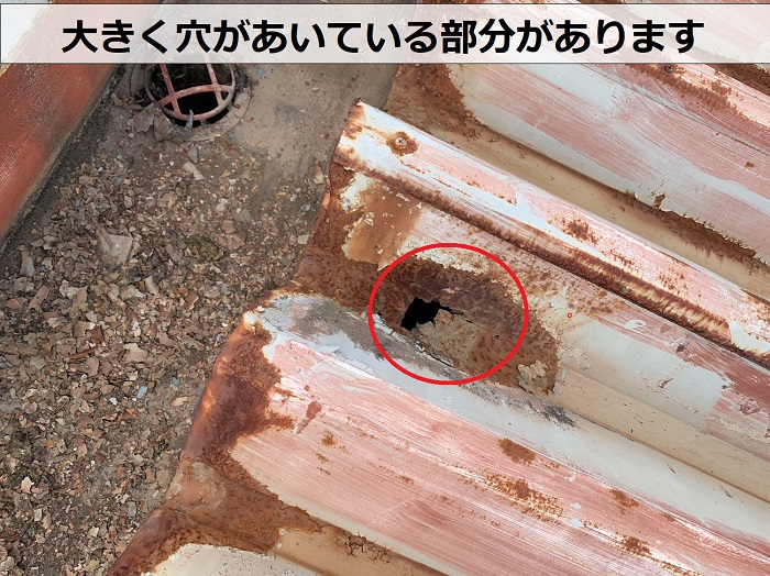 アパートの折板屋根に大きな穴があいている様子