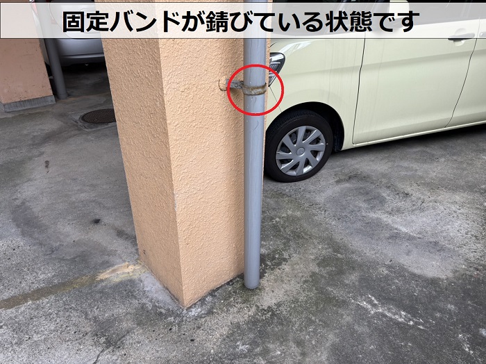 老朽化した竪樋の固定バンドが錆びている様子