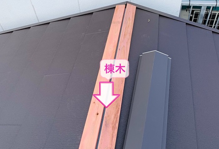 テラスハウスの屋根カバー工法で棟木を取り付けている様子