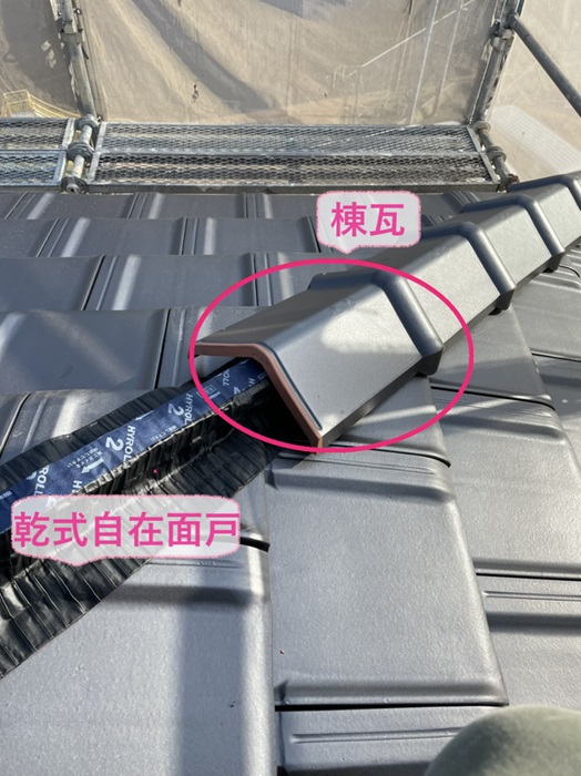神戸市長田区の屋根改修工事で棟木の上に乾式自在面戸を貼って棟瓦を取り付けている様子