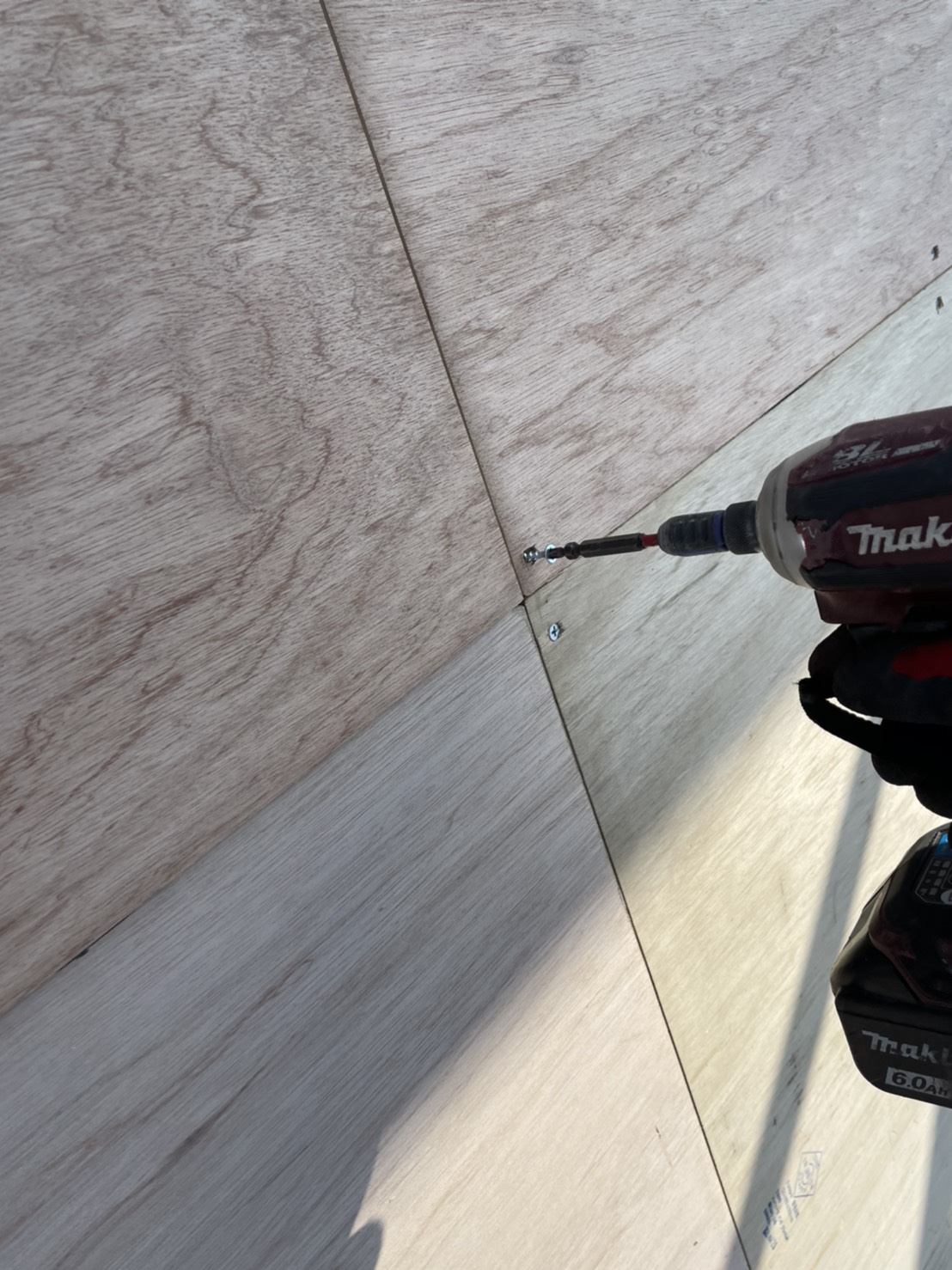 下地用合板をビスで固定している様子