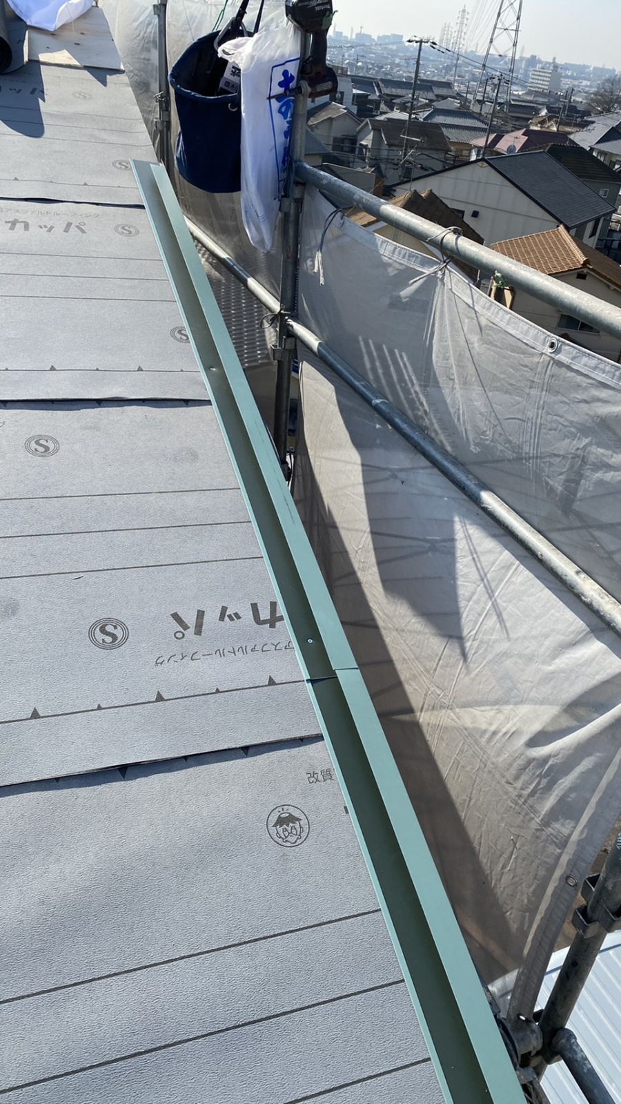 神戸市垂水区での金属屋根葺きでケラバ部に水切りを取り付けている様子