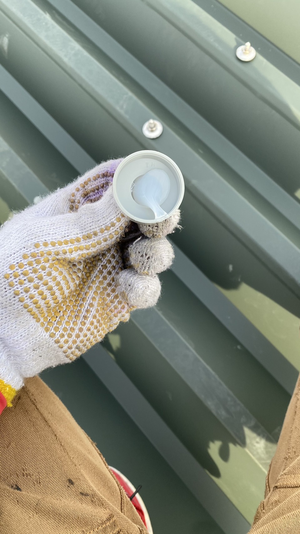 明石市での屋根工事でボルトにキャップを取り付けている様子