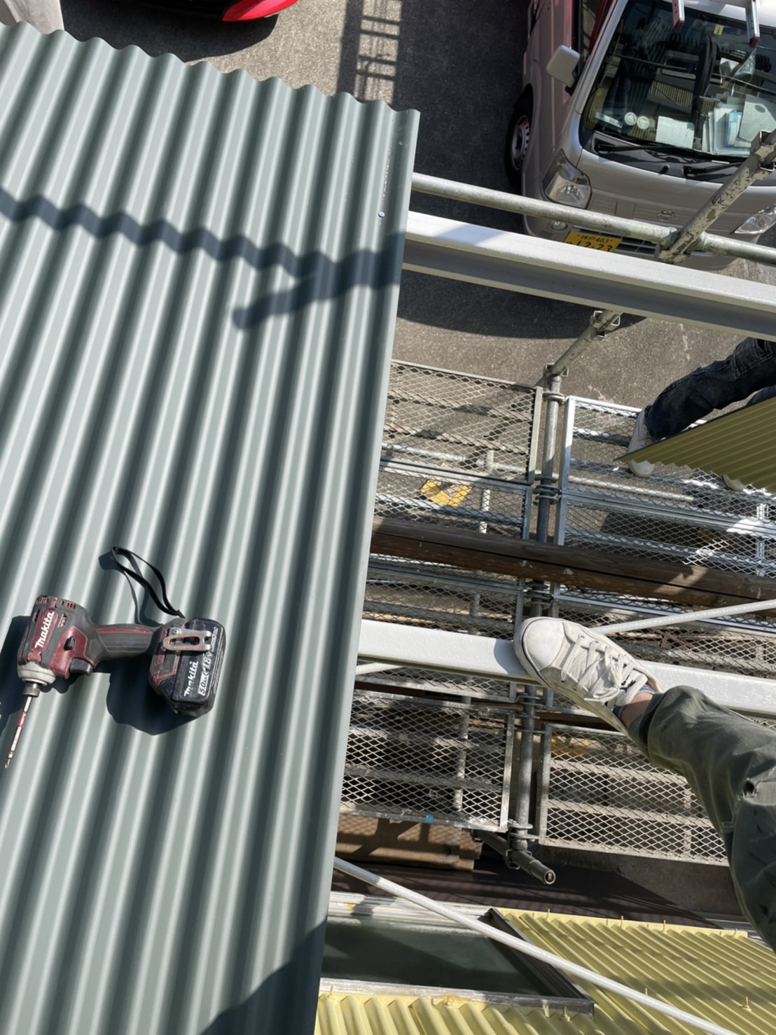 倉庫の庇にガルバリウム鋼板波板を貼っている様子