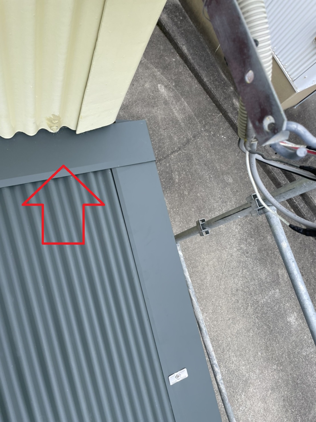 ガルバリウム鋼板波板の壁際に雨押え板金を取り付けた様子