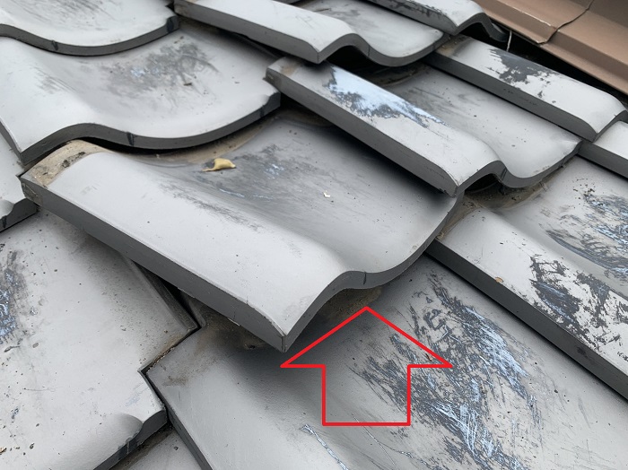 瓦が浮いて雨漏りしている様子