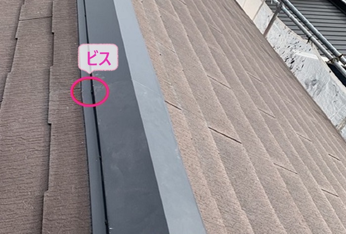 棟包み板金の部分補修で新しく取り付けた棟板金をビスで固定している様子
