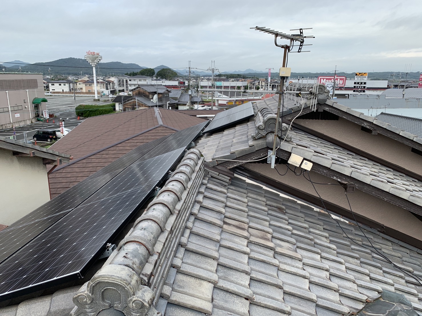 古くなっている瓦屋根の上に太陽光パネルが乗っている様子
