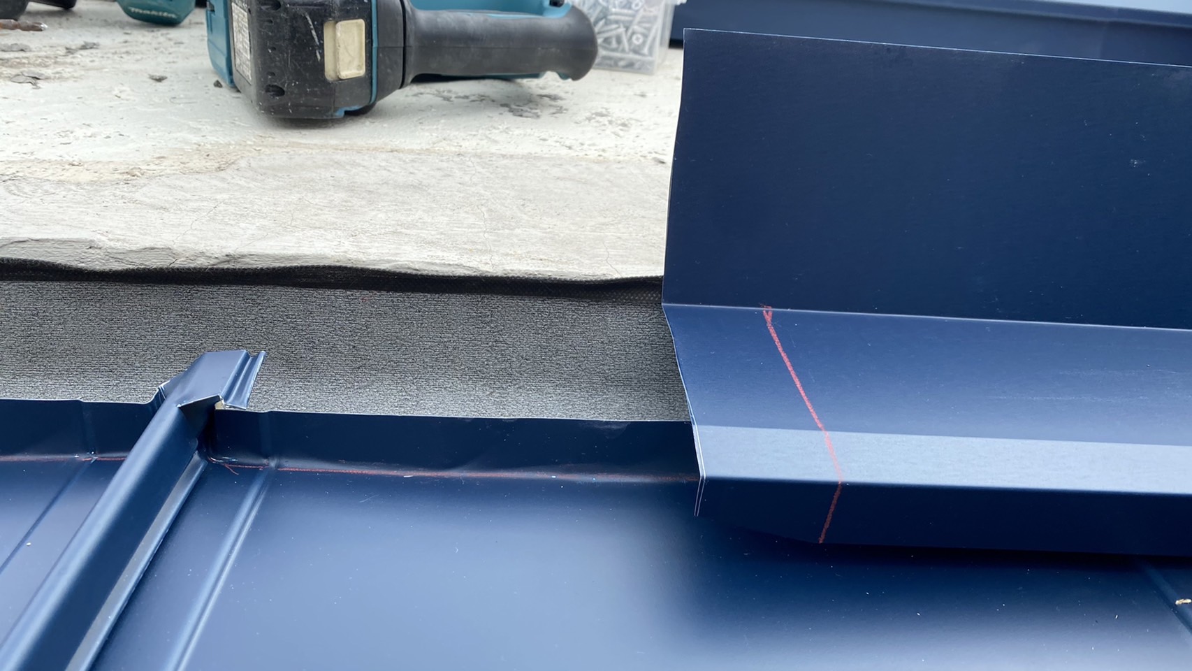 屋根板金工事で雨押えを取り付けている様子