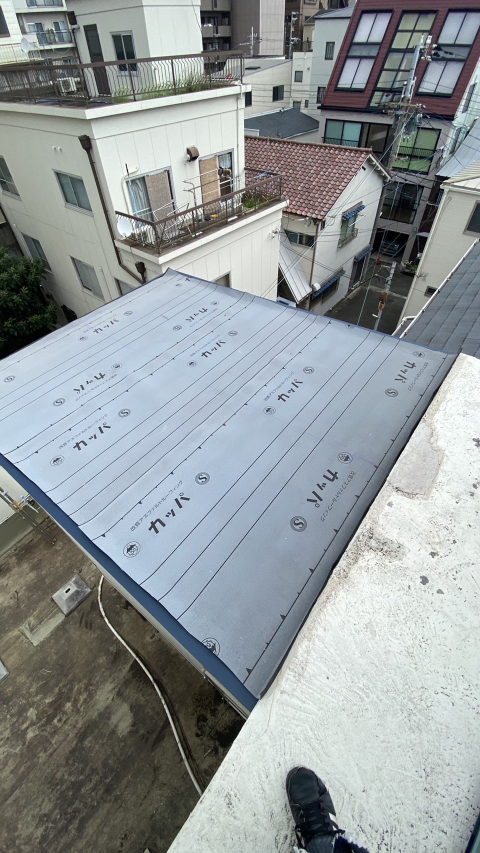 傾斜の緩い屋根に防水シートを貼った様子