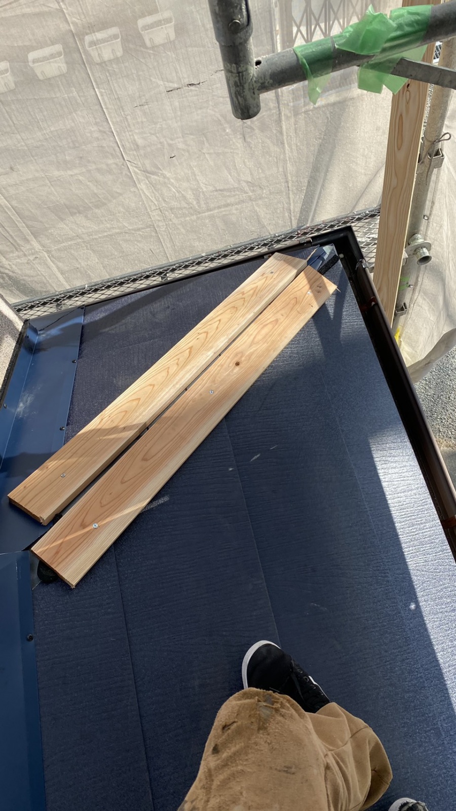 屋根カバー工事で棟板金を取り付けている様子