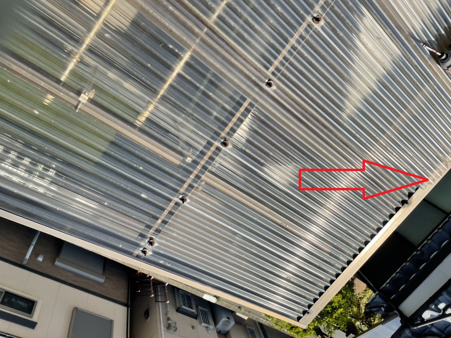 ベランダ屋根の波板が外れて飛散しそうな様子