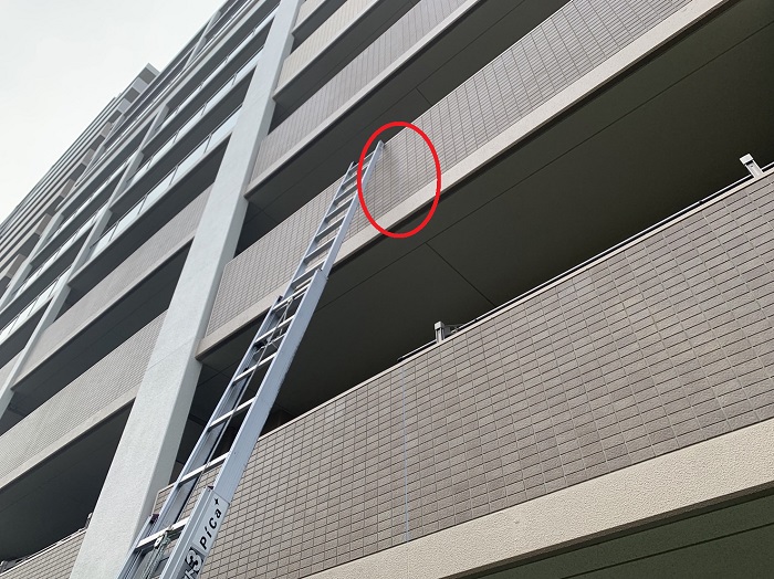 マンションの雨漏り補修箇所に梯子をかけた様子