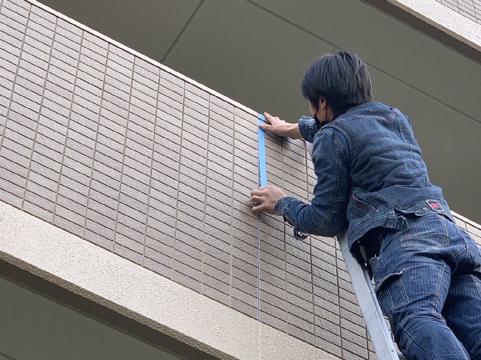 外壁からの雨漏り補修でマスキングテープを貼っている様子