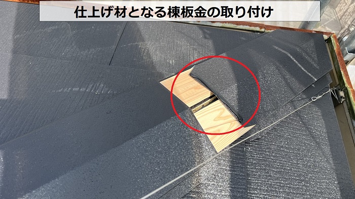 屋根カバー工事で仕上げ材となる棟板金を取り付けている様子