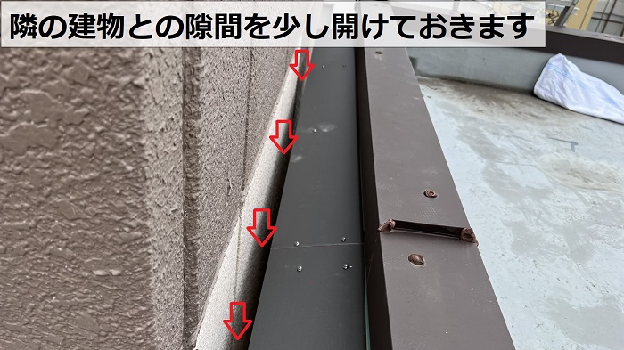 新しい庇屋根と隣の建物との隙間を少し開けている様子