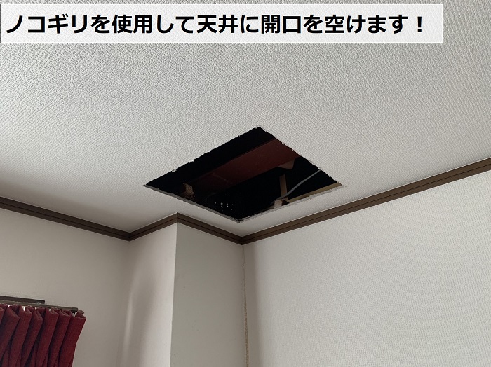 ノコギリを使用して天井に開口を空けている様子
