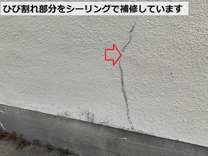 モルタル壁のひび割れ部分をシーリングで補修している様子