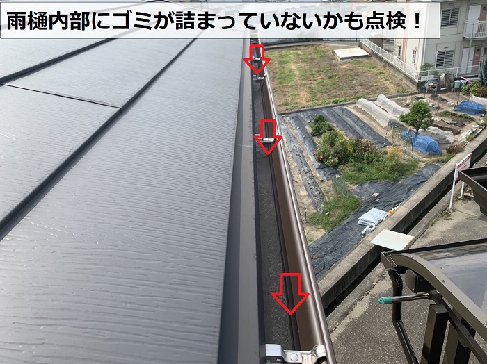 雨樋内部にゴミが詰まっていないか点検している様子