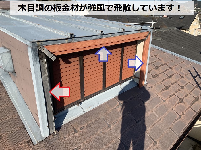 木目調の鳩小屋の板金材が強風で飛散している様子