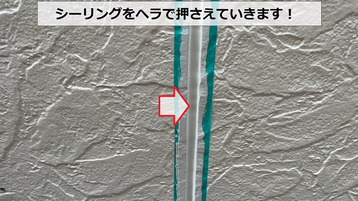 シーリングをヘラで押さえている様子