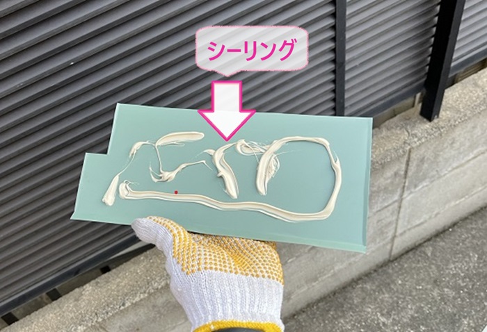 窯業サイディングの部分修理で板金材の裏にシーリングを塗っている様子