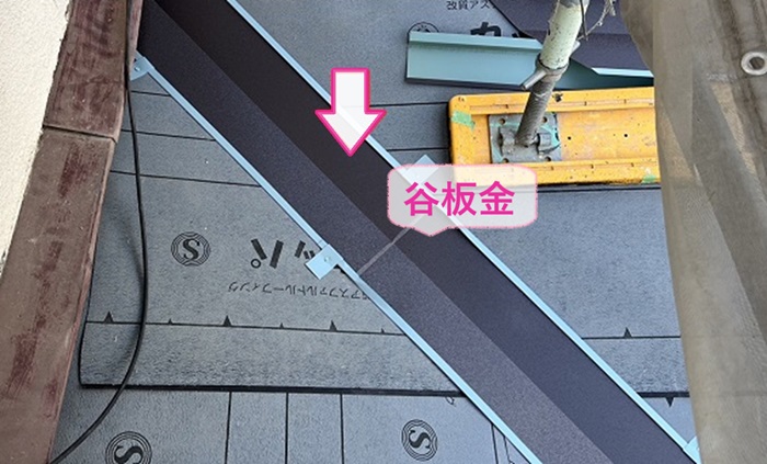 戸建て陶器瓦の貼り替えで谷板金を取り付けている様子