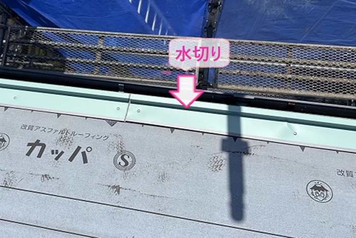 入母屋造りの戸建てスレート屋根重ね葺き工事で水切りを取り付けている様子