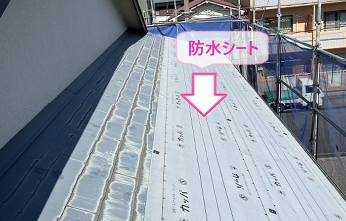 入母屋造りの戸建てスレート屋根重ね葺き工事で防水シートを貼っている様子