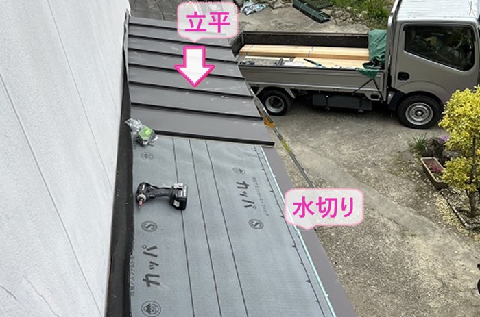 小庇の交換工事で屋根の先端に水切りを取り付けてガルバリウム鋼板製の立平を葺いている様子