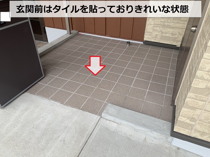 玄関前の土間にタイルを貼っている様子