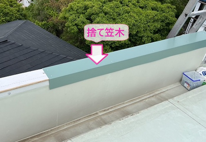 神戸市垂水区の雨漏り補修で屋上の笠木に捨て笠木を取り付けている様子