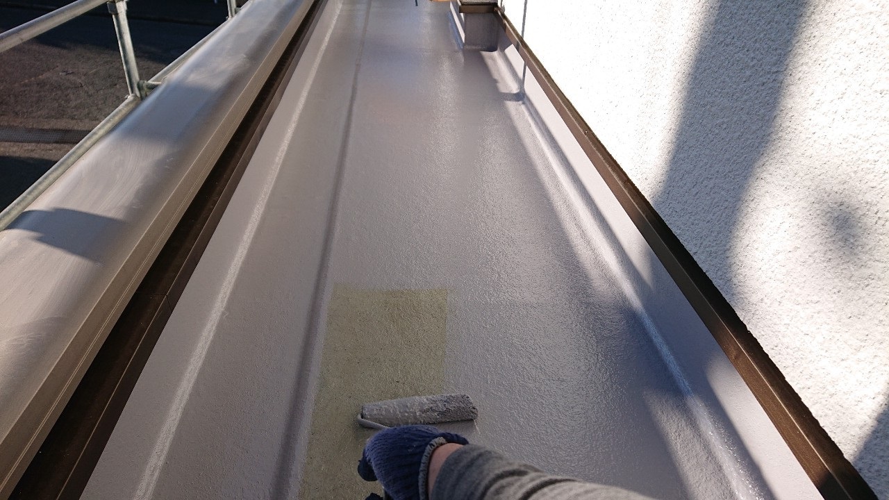 明石市の防水工事でトプコートを塗っている様子