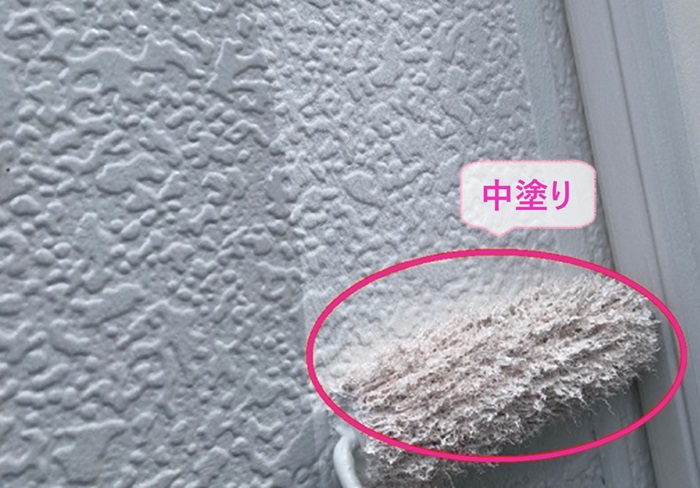 外壁1面だけ塗り替える戸建てでパーフェクトトップで中塗りしている様子