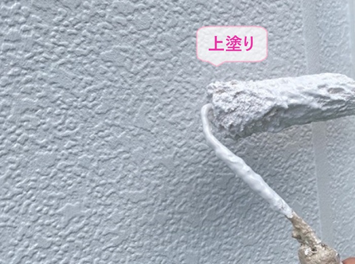 外壁1面だけ塗り替える戸建てで上塗りをしている様子