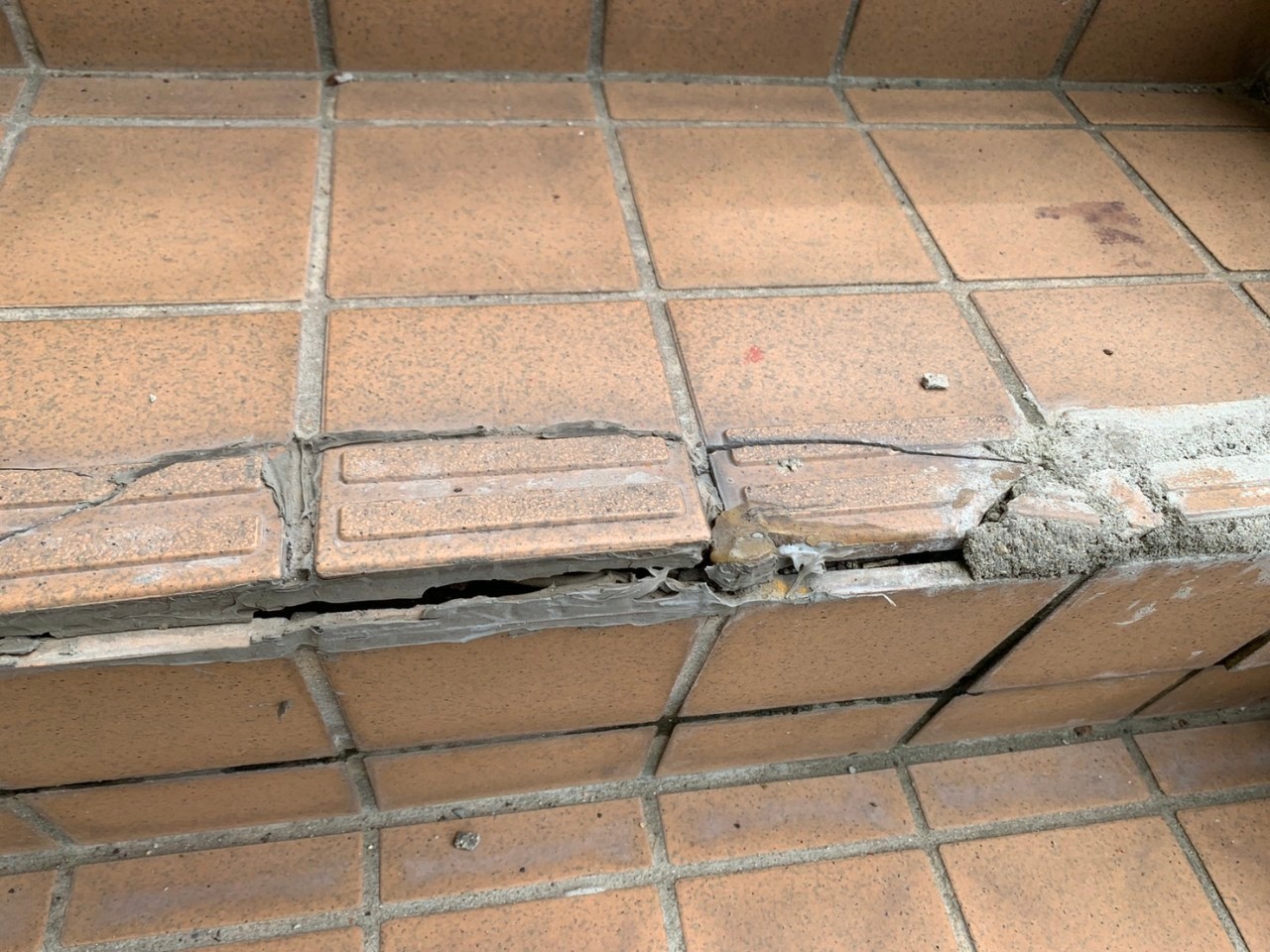 明石市で経年劣化した外部階段のタイルがひび割れている様子
