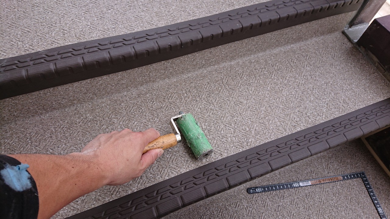 外部階段に長尺シートを貼っている様子