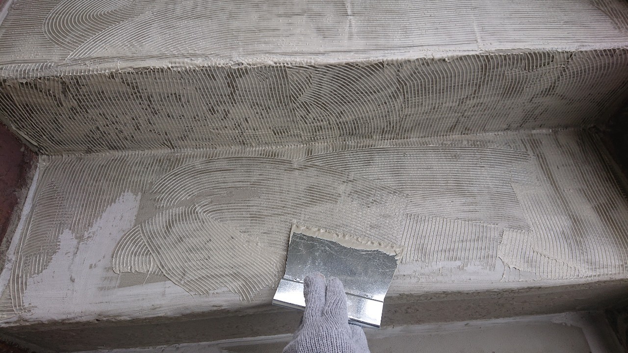 明石市の外部階段リフォームでノリを塗っている様子