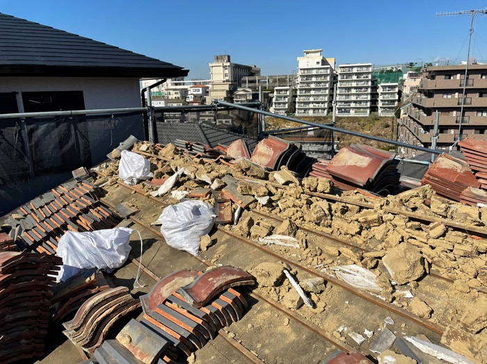 重たい瓦屋根と土を撤去している様子