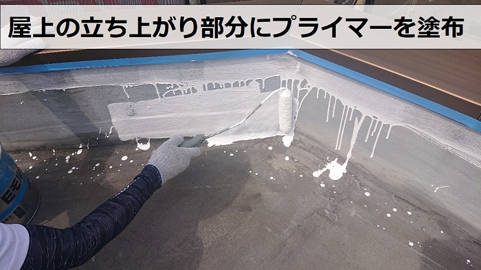 屋上の立ち上がり部分にプライマーを塗っている様子