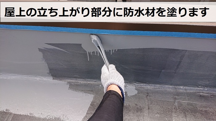 屋上の立ち上がり部分に防水材を塗っているようす