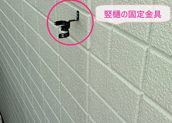 雨水排水設備の交換で竪樋の新しい固定金具を取り付けている様子