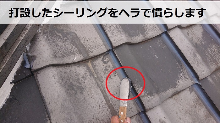 瓦屋根のズレ止め修理でシーリングをヘラで慣らしている様子