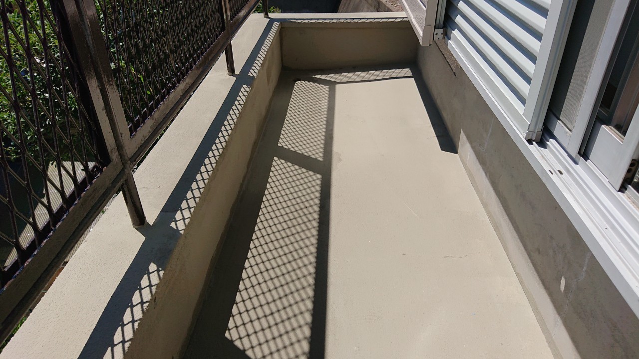 播磨町でのベランダ防水工事でひび割れたベランダ床にセメントを塗った様子