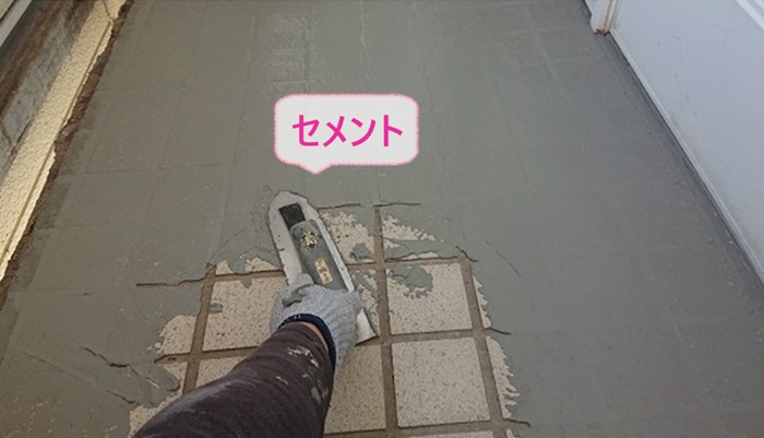 外階段のメンテナンスで踊り場の部分にセメントを塗っている様子