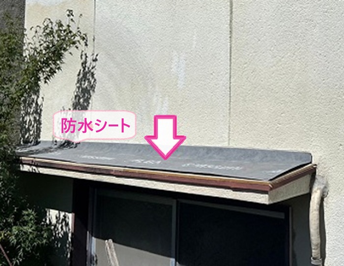 小庇の補修で防水シートを貼っている様子