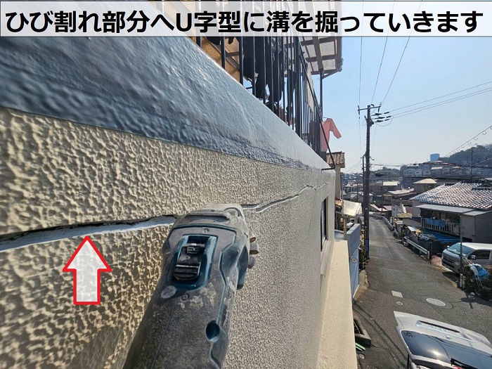 神戸市長田区で外壁のひび割れ部分にU字型に溝を掘っている様子